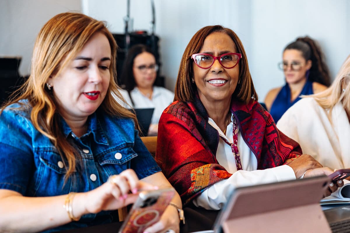 Participantes sonriendo mientras practican juntas con sus tabletas