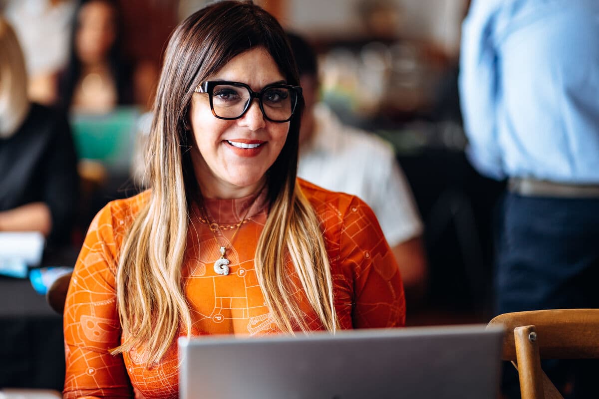 Participante sonriente frente a su laptop durante el taller